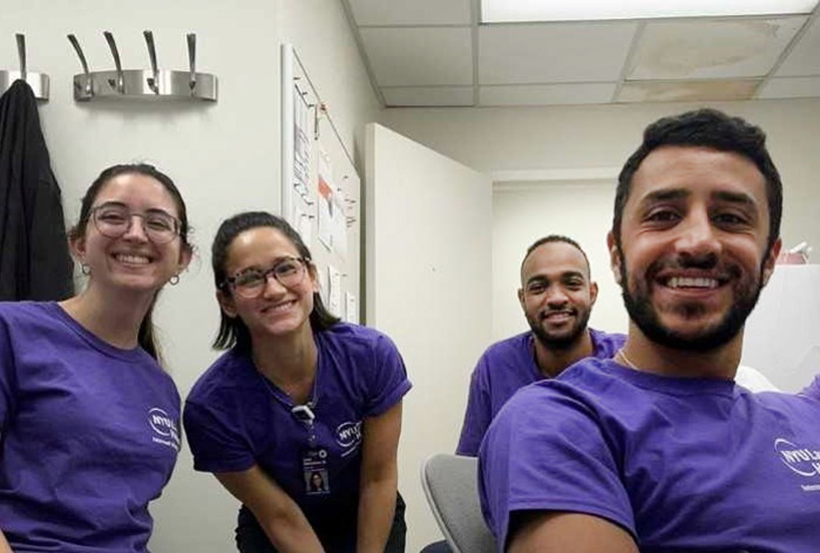 Four smiling residents posing for photo in call room